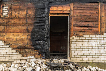 charred wooden parts of a burnt house in countryside