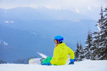 Fototapeta na wymiar Girl snowboarder enjoys the winter ski resort.