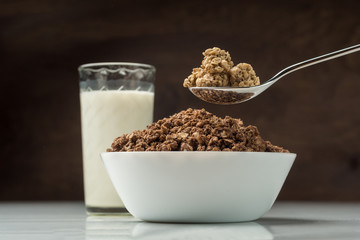 Bowl with granola owith glass of milk.