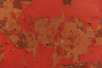 Texture of brown wall with cracked red paint