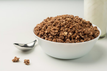 Bowl with granola owith glass of milk.