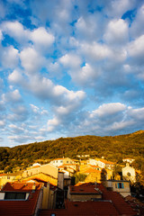 ancient Ligurian village in the mountains lit by the rising sun the clouds sky