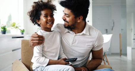 Relaxed african american family watching tv at home