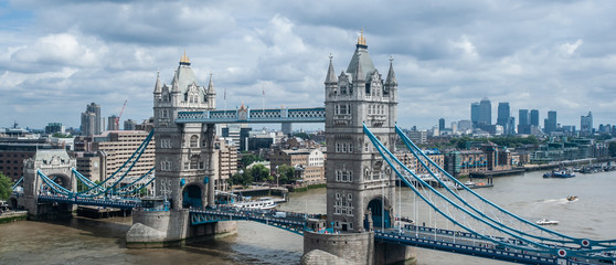 London, UK - Panoramic view of Tower Bridge, skyscrapers of Canary Wharf and the financial district and river Thames.  Unique elevated aerial view from above. Cloudy scattered sky