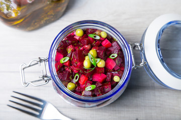 Vinaigrette salad with olive (vegetable) oil in a jar. Selective focus, close-up.