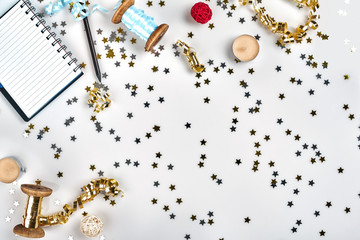 Flat Lay Christmas or Party Background with colored ribbons, decorations, confetti, and wrapping paper. Notepad for Text