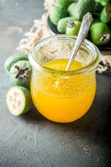 Tropical fruit preserves, homemade feijoa and lime jam on a dark blue concrete background, copy space