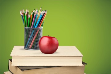 Stack of colorful notebooks, stationery and apple