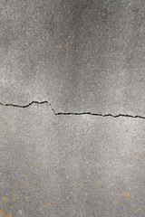 Crack in the structure of a grey concrete wall