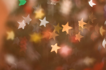 Defocused Christmas tree, colorful star shaped bokeh, Christmas background.