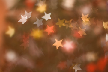 Defocused Christmas tree, colorful star shaped bokeh, Christmas background.