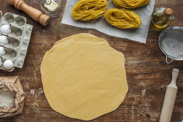 top view of rolled dough for pasta on wooden table
