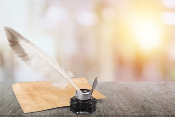 White feather quill pen, glass inkwell and old letter