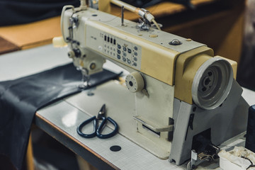 selective focus of tailor workplace with sewing machine at workshop