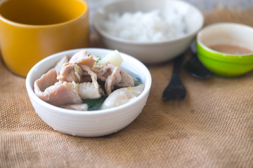 Suki in broth with pork on white bowl