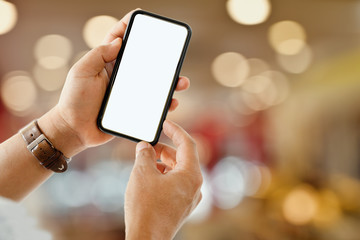 Close up of male hand holding blank screen smartphone with blurred bokeh background