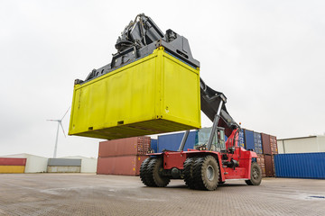 Reach-Stacker carrying a yellow container