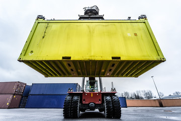 Reach-Stacker carrying a yellow container
