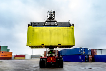 Reach-Stacker carrying a yellow container