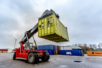 Reach-Stacker carrying a yellow container