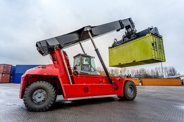Reach-Stacker carrying a yellow container