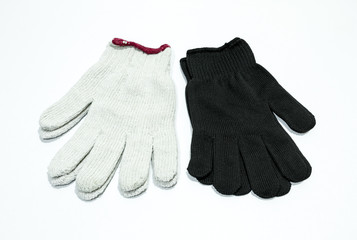 White and black cloth gloves for hand wear on white floor.