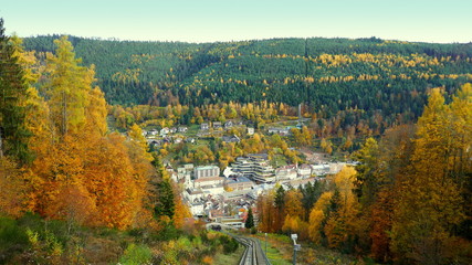 Blick von der Sommerbergbahn auf Bad Wildbad durch bunten Herbstwald im Schwarzwald
