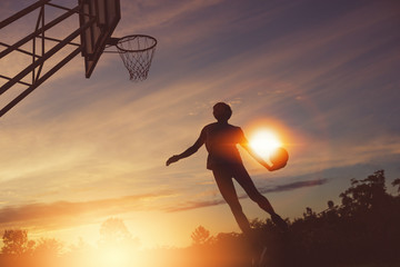 Basketball player performs a slam dunk © sutadimages