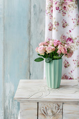 Bouquet of pink roses in ceramic vase.
