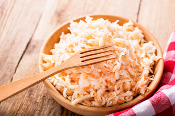 sauerkraut in a wooden bowl on a board
