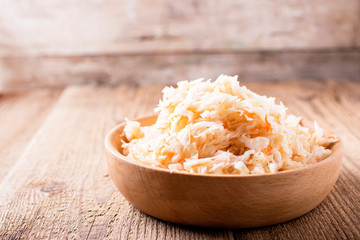 sauerkraut in a wooden bowl, on a board, side view, copyspace