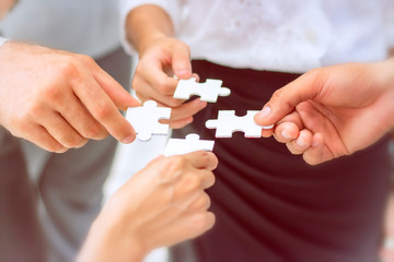 Business concept; Group of business people assembling jigsaw puzzle and represent team support and help together