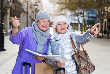 Senior females traveling with city map
