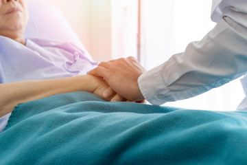 The doctor visits the sick and encourages the hospital.Concept of healing care. The doctor is healing old woman. The doctor is working in the hospital. Doctors encourage and treat elderly patient.