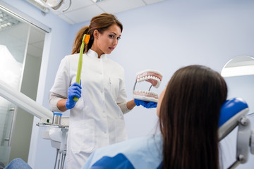 Girl at the dentist learning how to brush her teeth