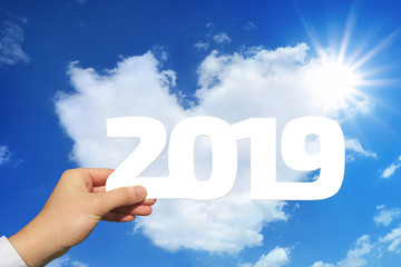 2019年を持つ男性の手と青空とハート型の雲と太陽