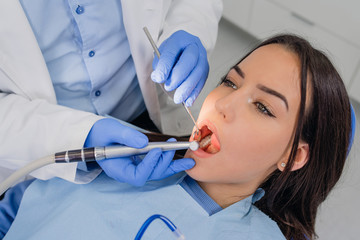 Fototapeta premium Dentist check up and repair tooth of young girl
