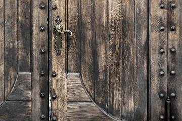 part of an old antique  black wooden door with metal elements