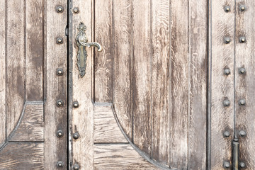 part of an old antique  grey wooden door with metal elements
