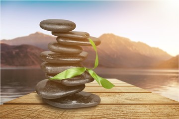 Zen basalt stones and leaves on background