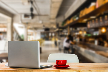 Workplace with notebook laptop and coffee cup Comfortable work table in cafe.