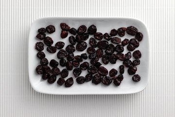 Cranberries on rectangular white plate with rounded corners.