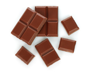 Milk chocolate pieces on white background