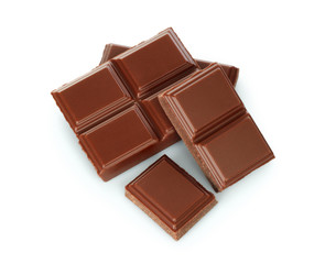 Milk chocolate pieces on white background