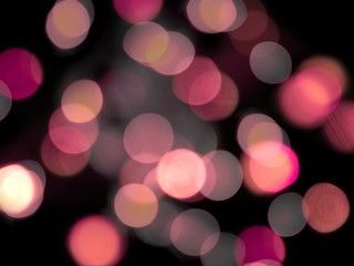 Pink glowing blurred round lights on a black background