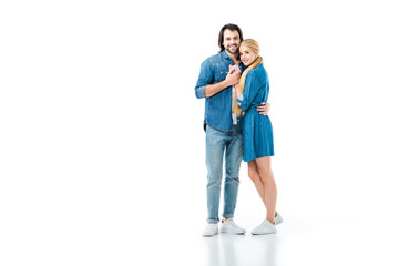 Fototapeta premium Girl in denim dress and man in jeans and denim shirt hugging each other isolated on white