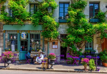 Schilderijen op glas Cozy street with flowers and tables of cafe  in Paris, France © Ekaterina Belova