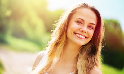 Naklejka premium Young woman on field under sunset light