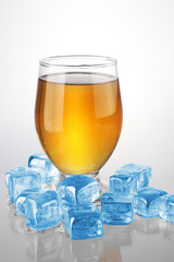 a glass of beer with ice cubes