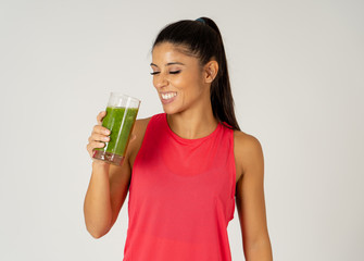 Happy beautiful fit sport woman smiling and drinking healthy fresh vegetable smoothie